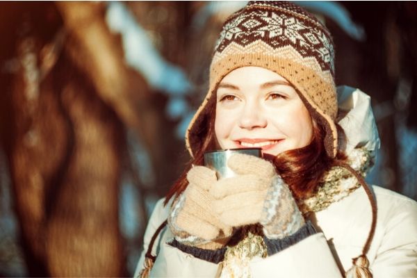 girl in a cold climate drinking a warm  fluid